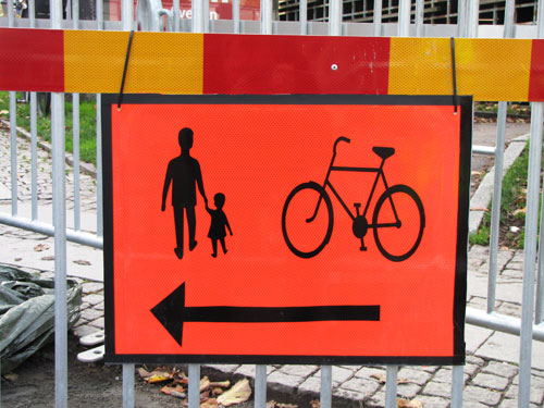 Orange J2-skylt Pil för gående och cyklister