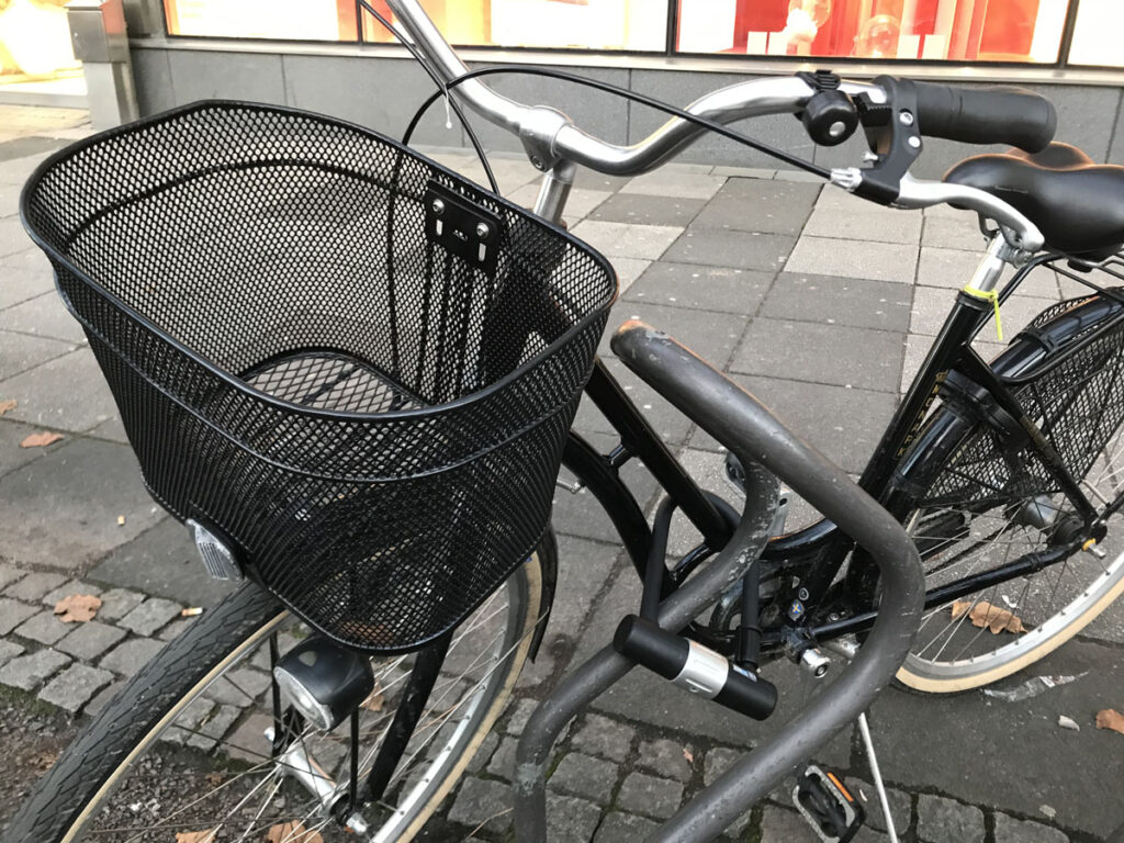 Cykel med korg bredvid Publicus-ställ