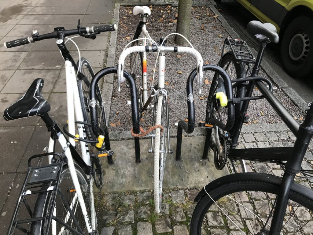 Tre cyklar bredvid två Publicus-ställ