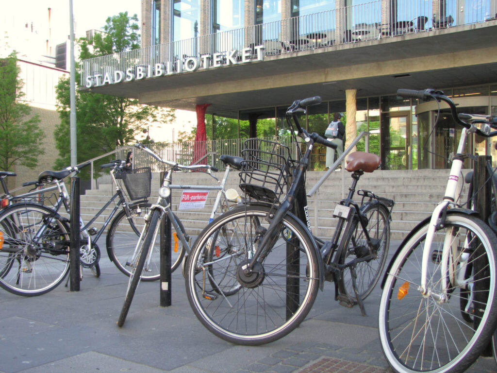 Fyra cyklar fastlåsta framför biblioteket