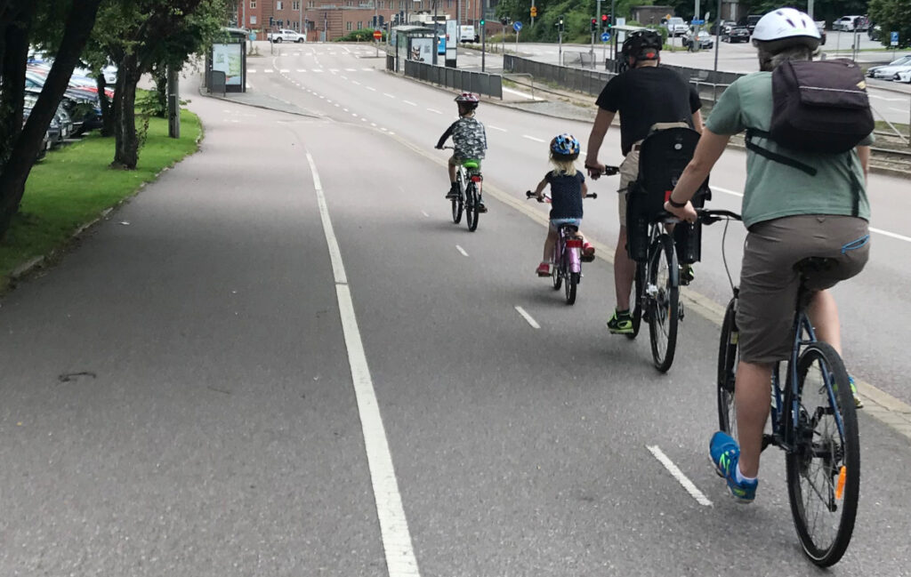 Barn cyklar med föräldrar