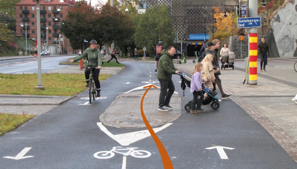 Cykla bakom gående som korsar